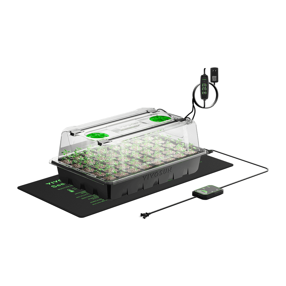 Seedling heat mat with black tray, clear vented dome, and small green seedlings inside against a black background.