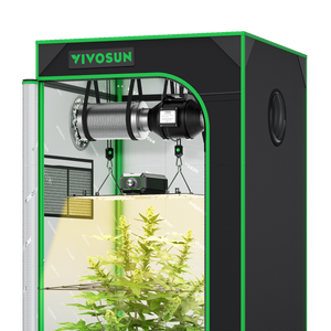 Black and green grow tent containing a hanging ventilation fan, LED grow light, and green plant.