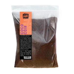 Clear plastic bag filled with dark brown coco coir mushroom substrate and casing layer, featuring an orange product label.