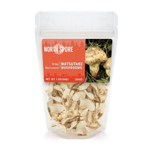 A clear plastic pouch of North Spore dried wild matsutake mushrooms with a bright orange label featuring mushroom imagery.