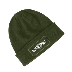 Olive green ribbed knit beanie with a rectangular patch reading "NORTH SPORE" on the folded cuff.
