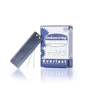 Blue box of Emboss-o-tag industrial data markers with one rectangular metal tag standing on wires.