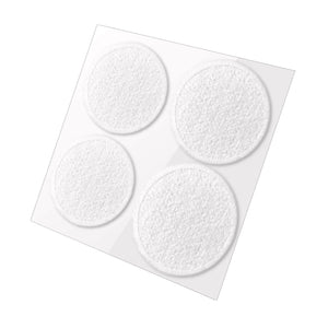 Four white, round furniture sliders on a clear plastic sheet.