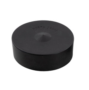Black round silicone cap with a small central injection port and North Spore embossed on top.