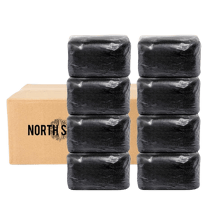 Two stacks of four black wrapped blocks in front of a cardboard box labeled North S.
