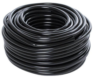 High-angle view of a neat, tight coil of flexible black irrigation tubing on a clean white background.