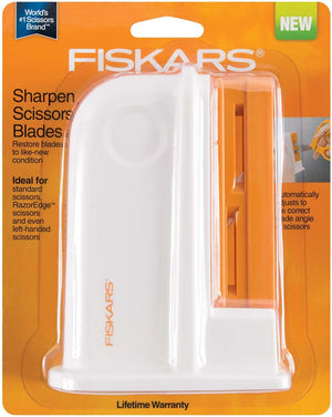 Fiskars white and orange scissor sharpener in original retail packaging, showing two sharpening slots.