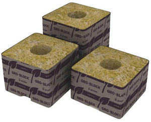 Three Grodan Gro-Block stone wool cubes with center holes, wrapped in purple branded plastic on white background.