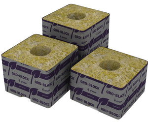 Three Grodan Gro-Block stone wool cubes in a triangular arrangement, each with a center hole and purple branding.