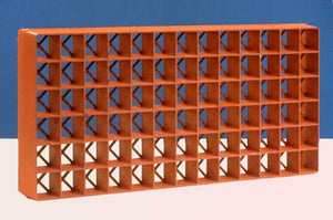 Terracotta-colored plastic seedling tray insert with a grid of square cells, viewed from a slightly elevated angle.