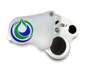 Top-down view of a handheld jeweler's loupe with a silver cover featuring a green and blue logo, LEDs, and lens.